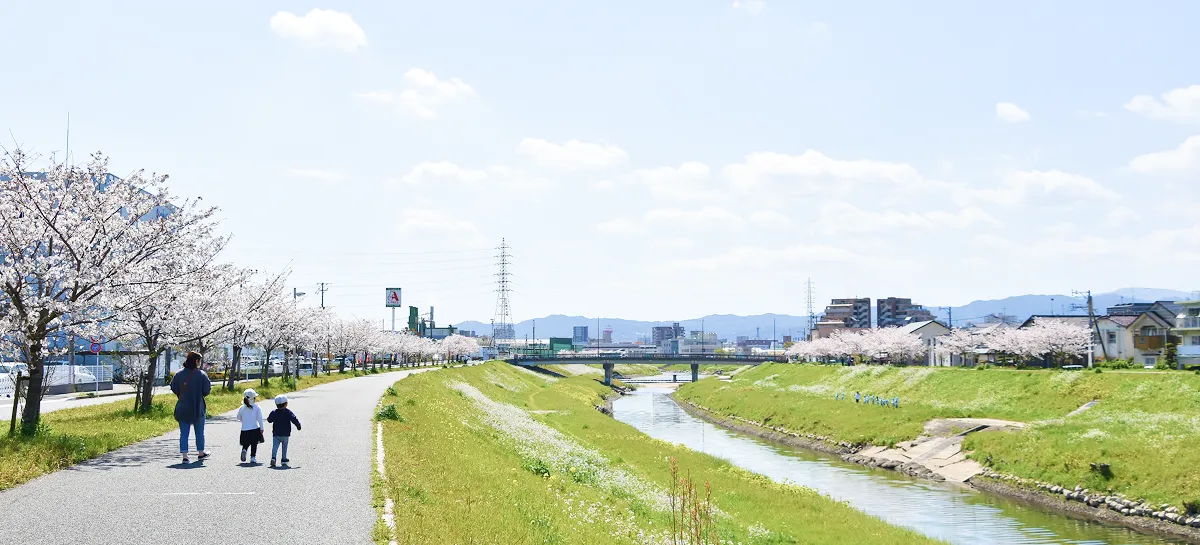 川辺で散歩する家族の写真