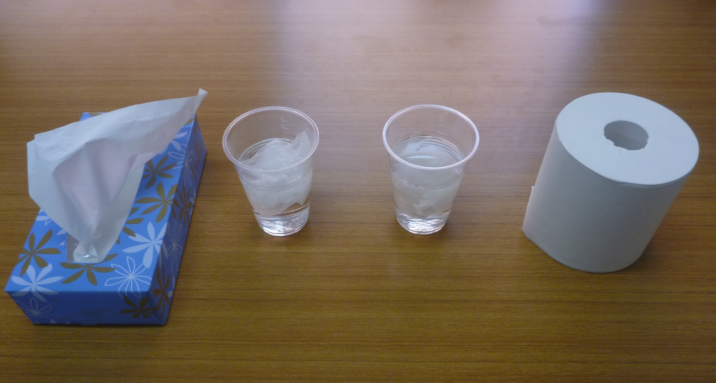 水を入れたコップにティッシュペーパーとトイレットペーパーを入れたもの